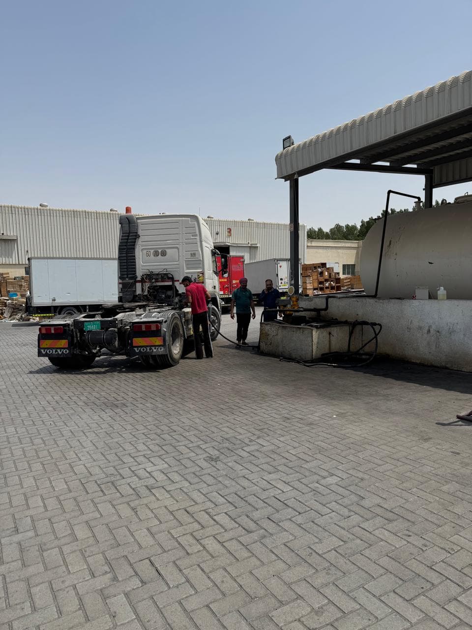 A tractor unit refuelling from a private on-site bulk diesel tank in a yard.